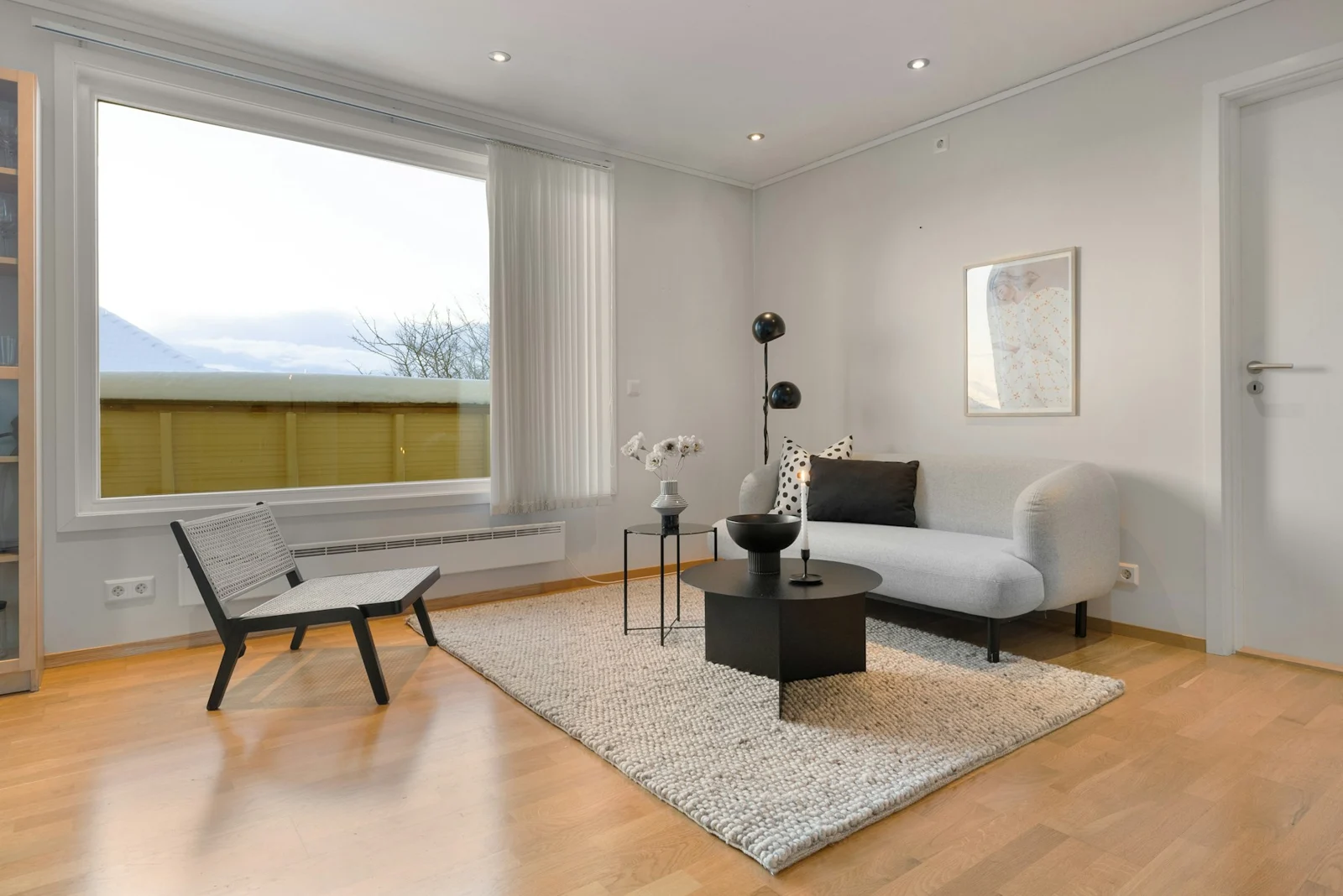 A living room with a couch, chair and book shelf；第三方摄影参考